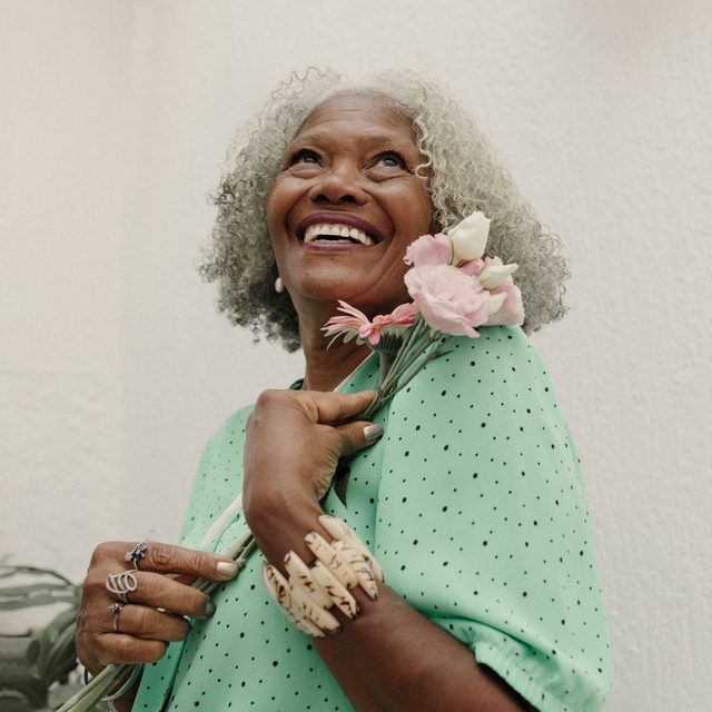Femme senior en haut vert à pois, sourire radieux