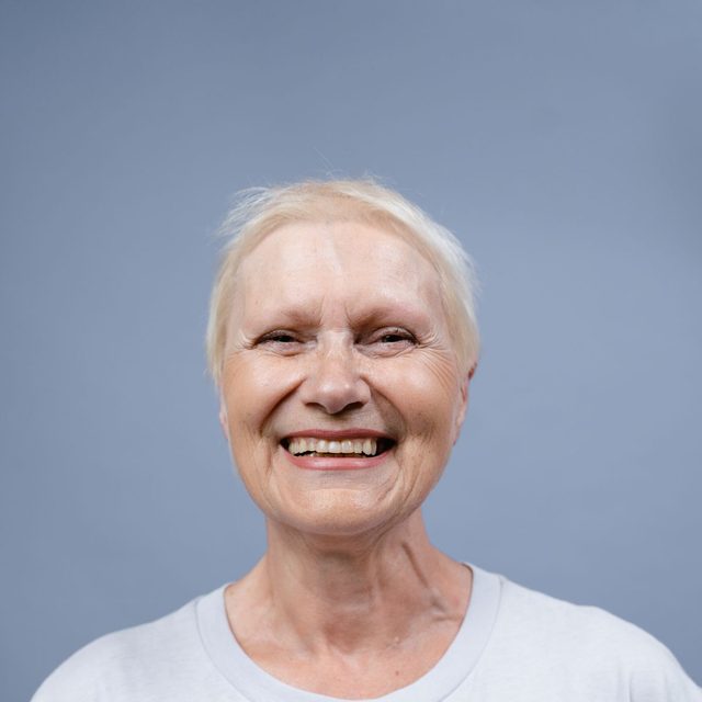 Femme senior aux cheveux blancs, haut clair, sourire paisible